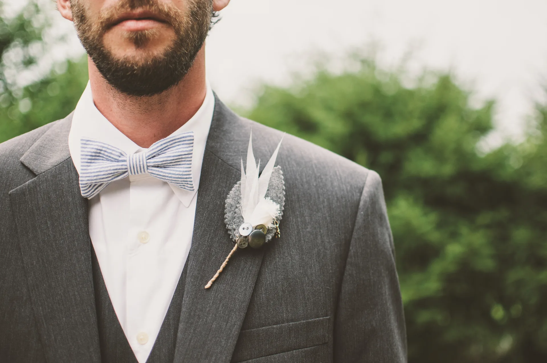 Grauer Hochzeitsanzug mit Fliege und persönlicher Ansteckblume